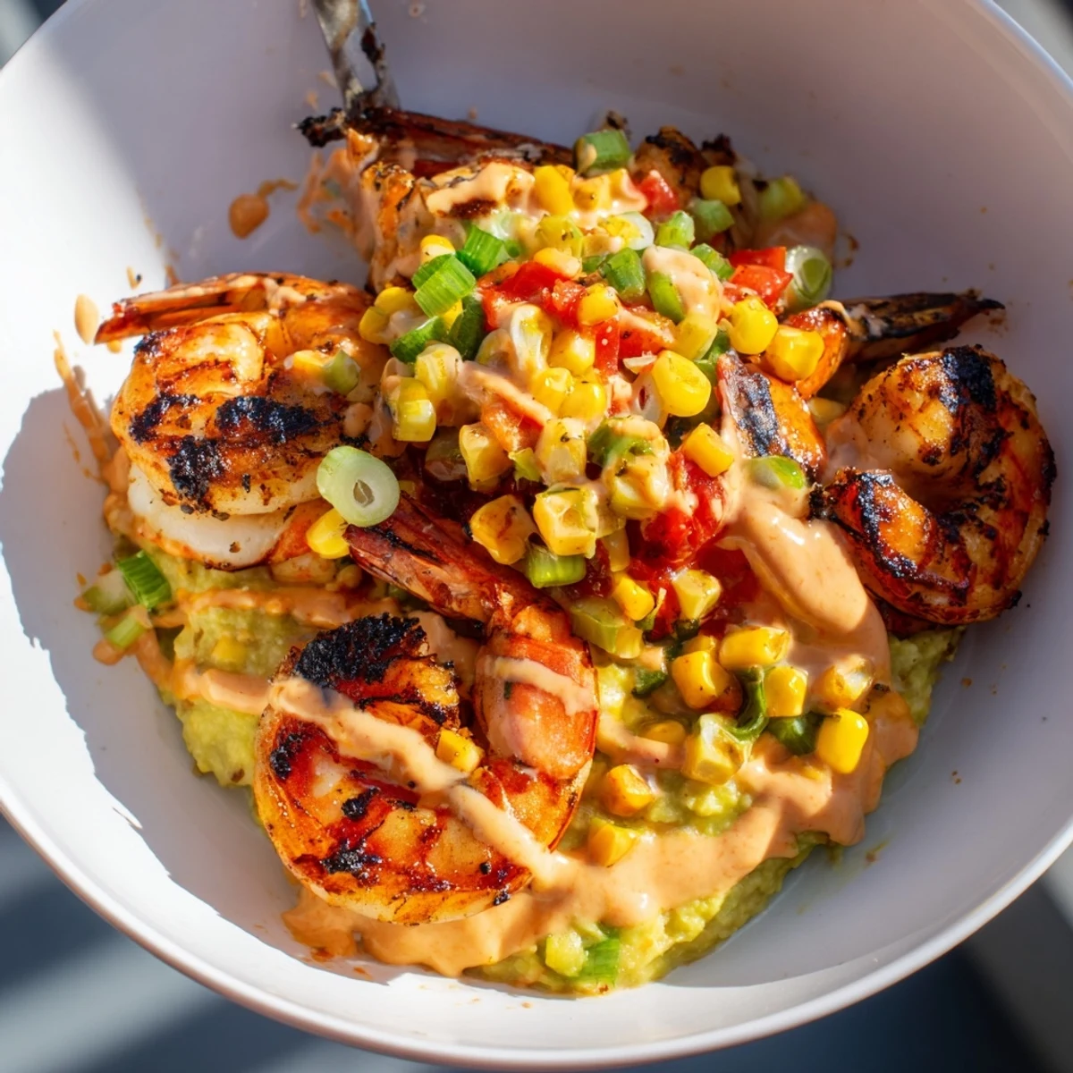 Delicious Grilled Shrimp Bowl with Avocado, Corn Salsa, and creamy sauce presented in a vibrant dish.  