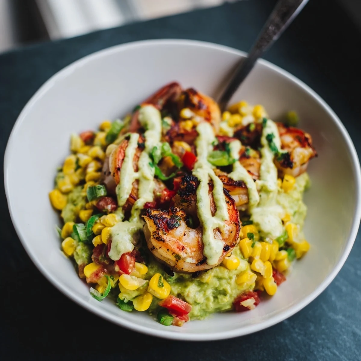 Savory Grilled Shrimp Bowl topped with fresh corn salsa, avocado, and a drizzle of sauce.