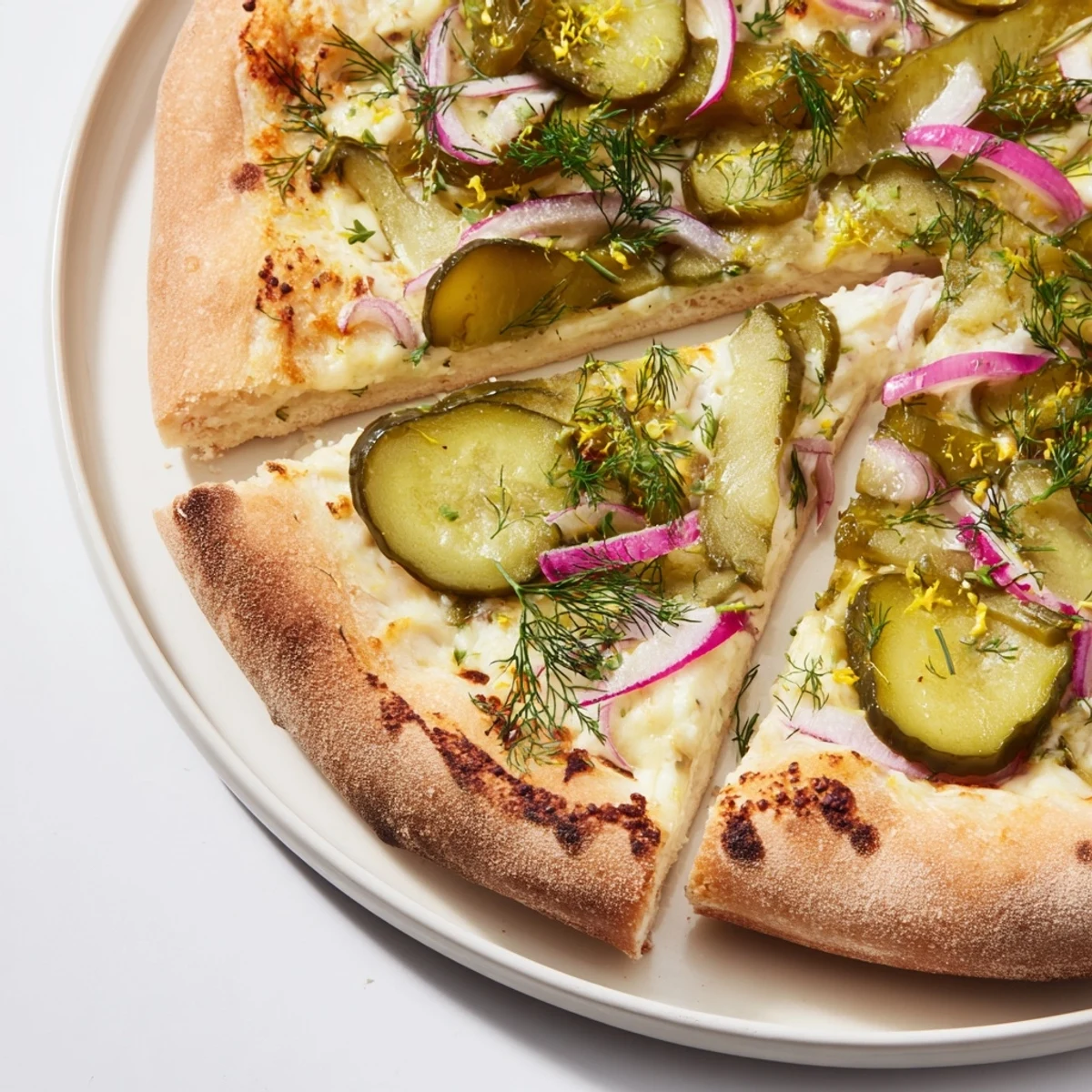 Tangy Pickle Pizza topped with creamy sauce, mozzarella, and crunchy pickles.  