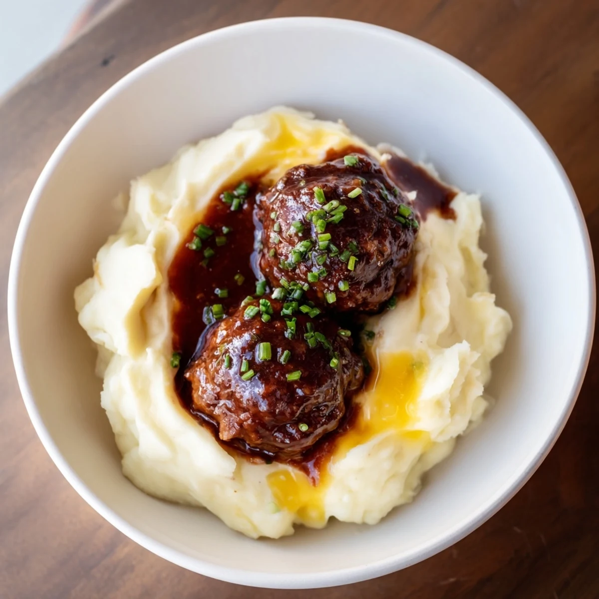 Juicy BBQ Meatballs served over fluffy mashed potatoes, a classic American comfort food dinner.