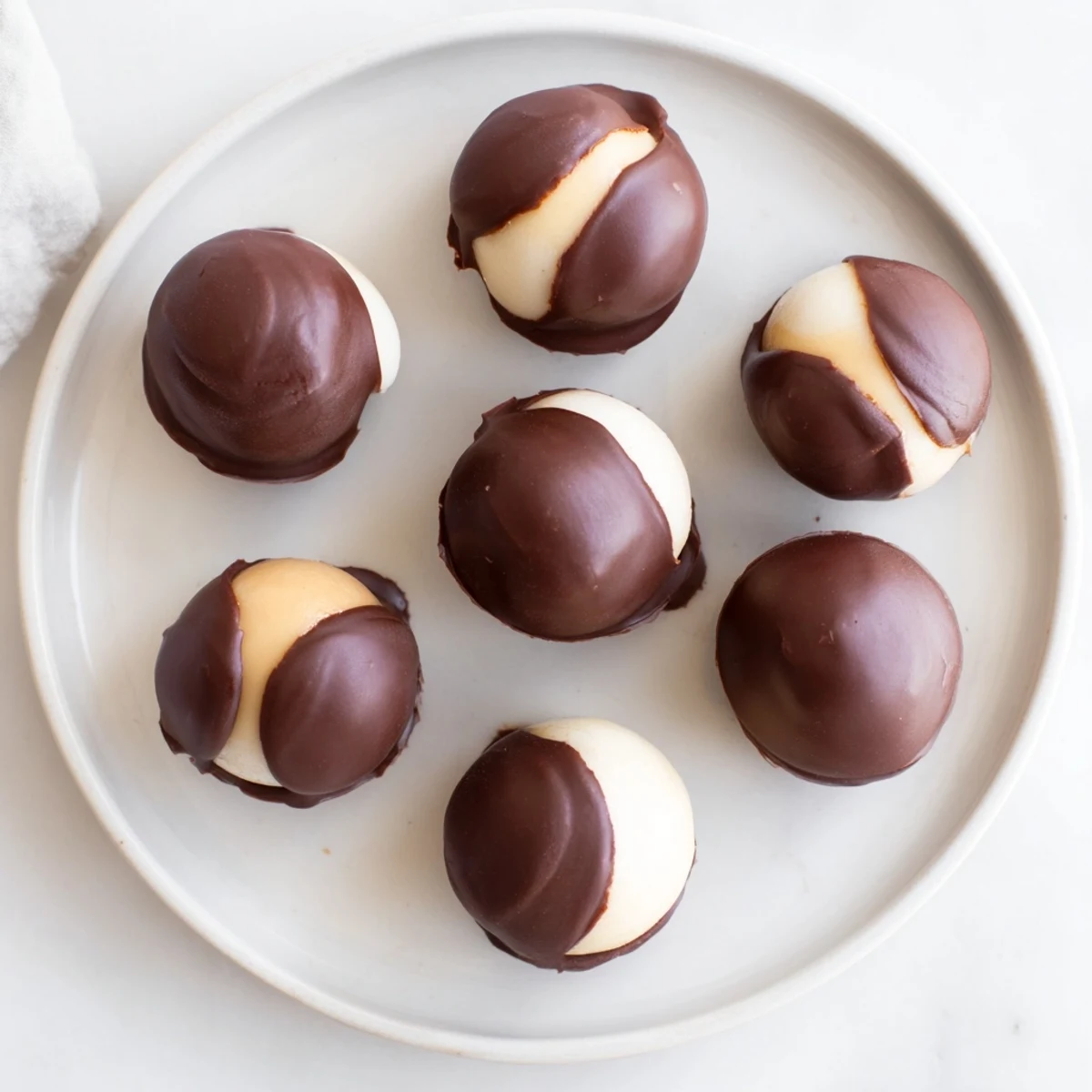 Homemade Peanut Butter Buckeyes arranged on a baking sheet, offering a sweet and classic American treat for any occasion.