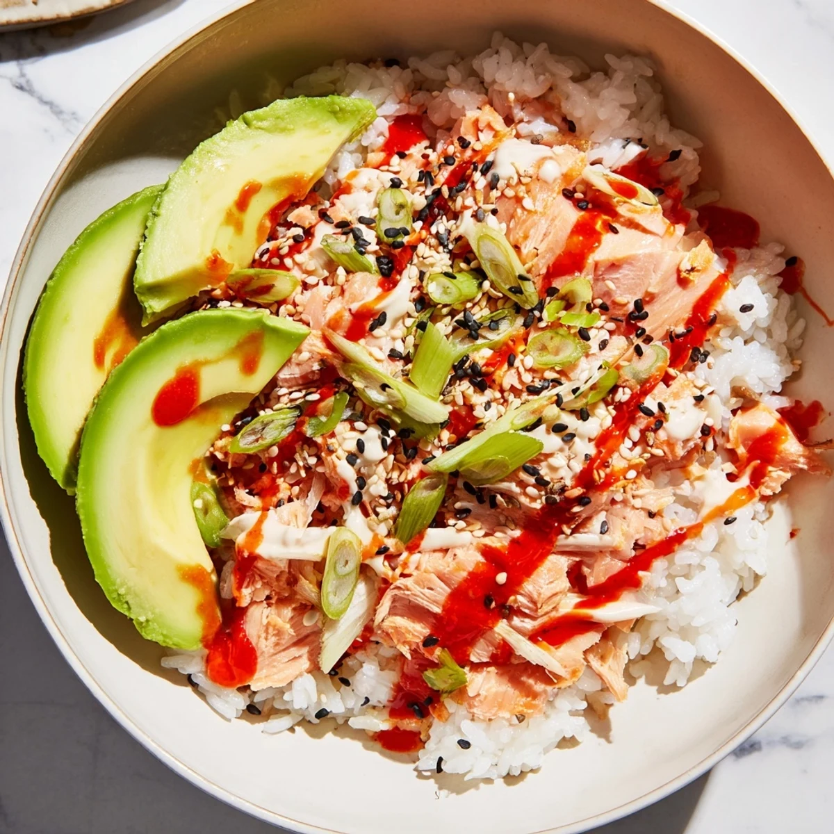 Steaming bowl of Classic Salmon Rice with creamy avocado slices, ready to enjoy.