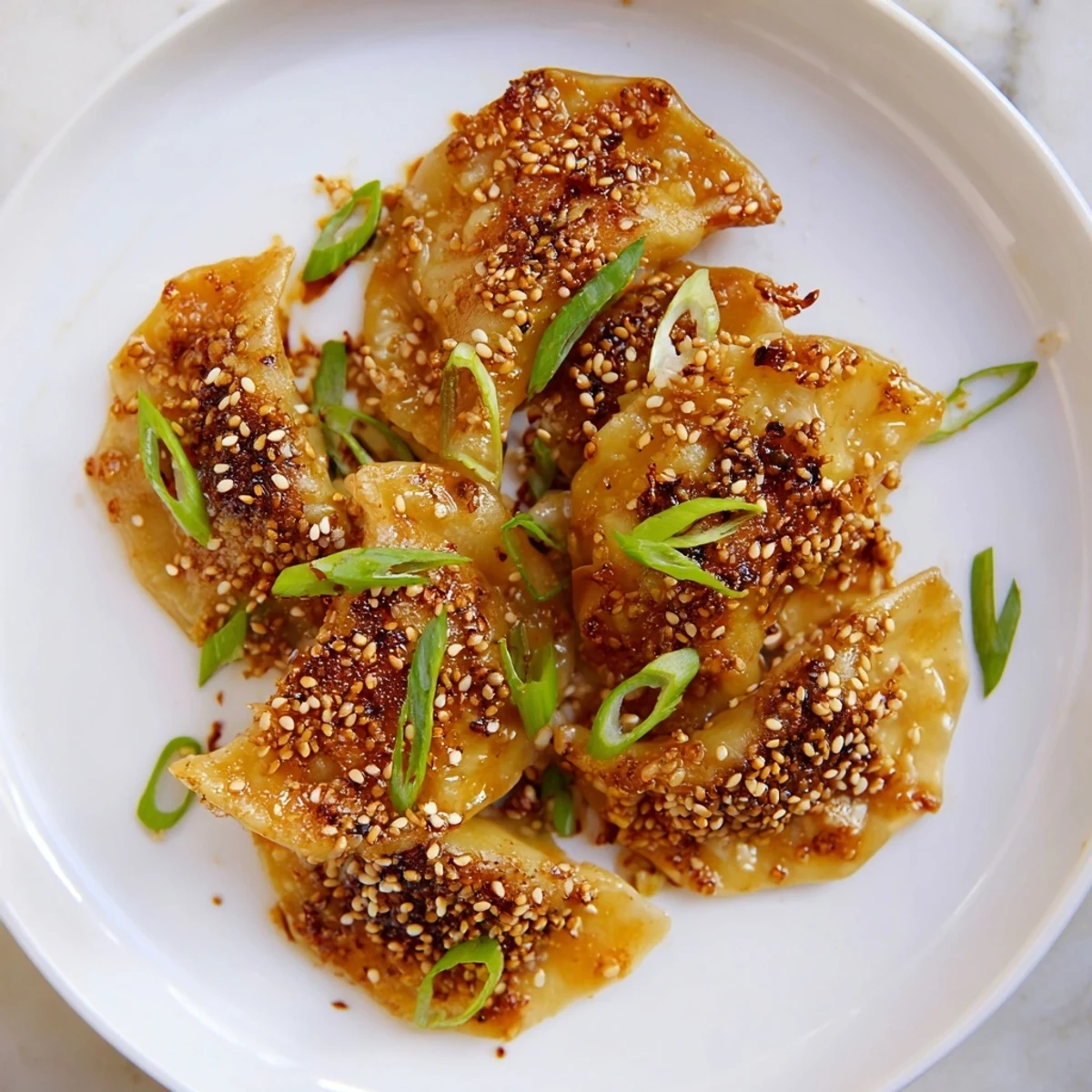 A close-up of air fryer frozen dumplings with a savory sesame oil glaze, perfect appetizer.