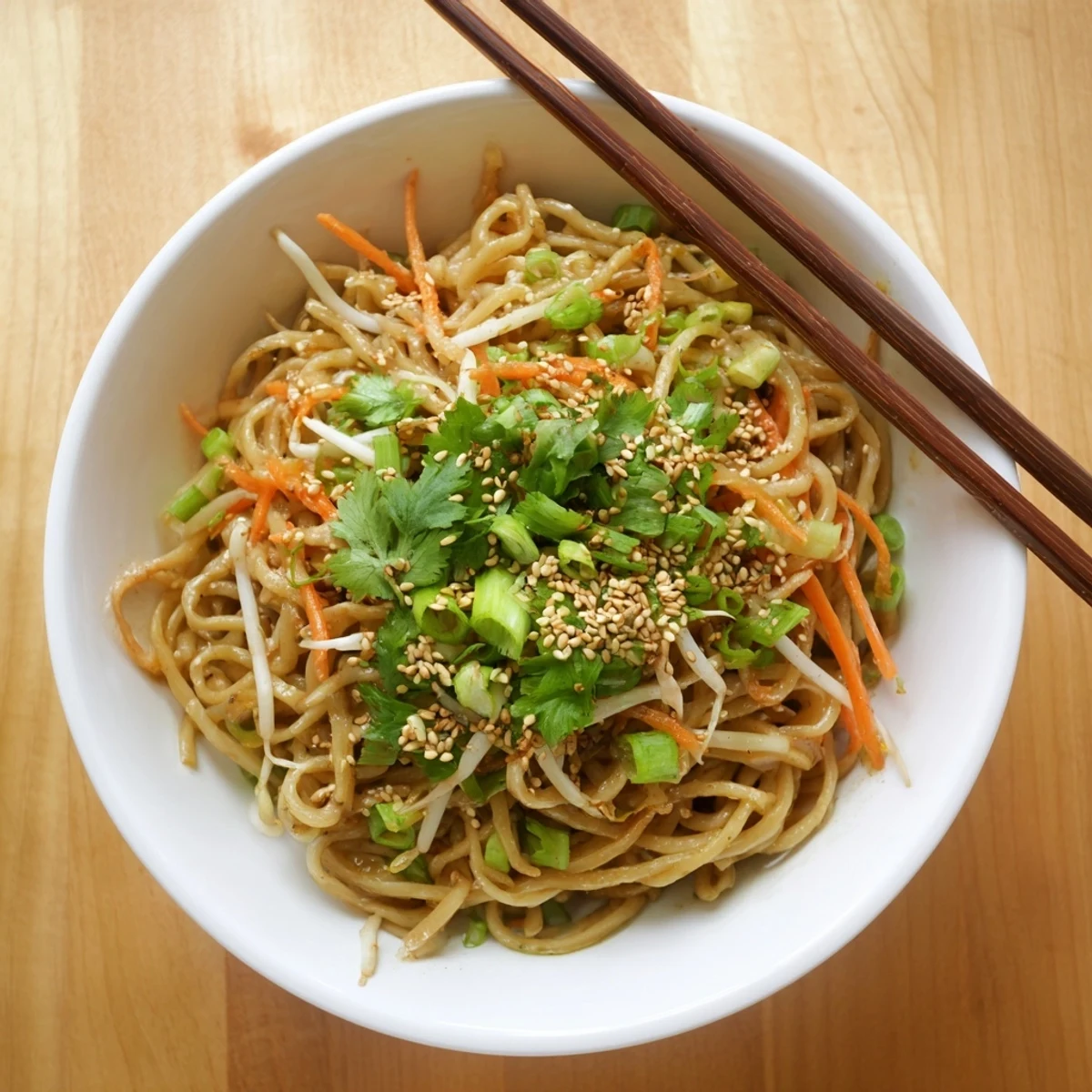 Close-up of glossy Asian Garlic Noodle Bowl tossed with crisp bean sprouts and carrots.