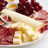 Festive Twelve Days of Christmas snack board overflowing with cheeses, fruits, and holiday treats.