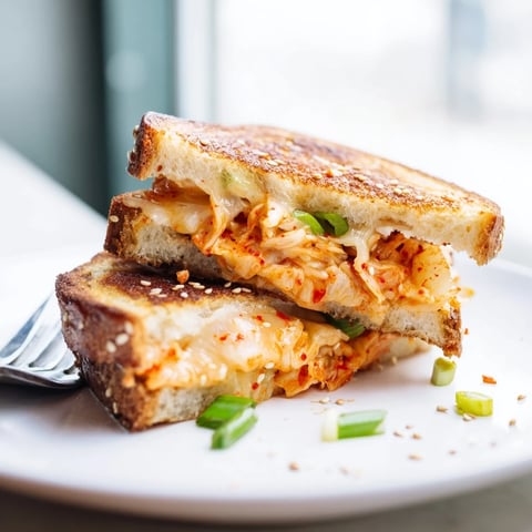 Golden, melty Skillet Kimchi & Cheddar Fusion Grilled Cheese with crispy bread crusts, ready to devour.
