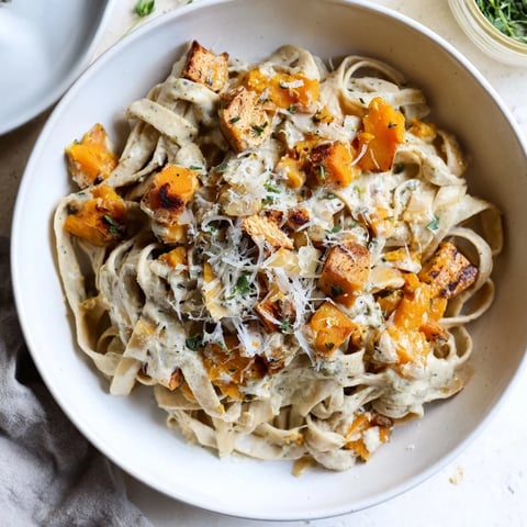 Healthy Creamy Pumpkin Sage Holiday Pasta, a warm, inviting bowl ready to serve with extra Parmesan cheese.