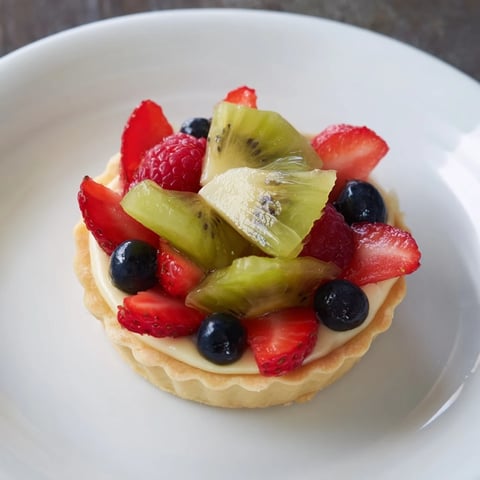 Circular arrangement of sweet Mini Fruit Tartlets, showcasing vibrant colors of fresh berries and kiwi.