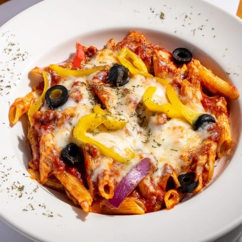 One-Pot Pizza Pasta steaming, topped with melted mozzarella and colorful pizza toppings.