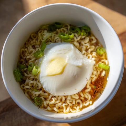 Delicious upgrade instant ramen with a perfectly cooked soft egg, swimming in savory broth and butter.