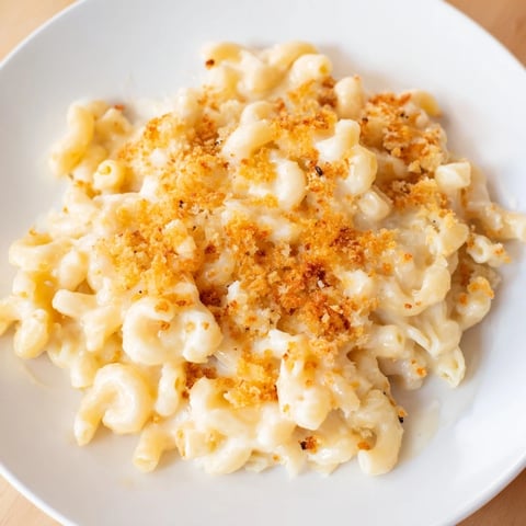 A close-up shot of rich and creamy mac and cheese, perfectly golden-brown and bubbling.
