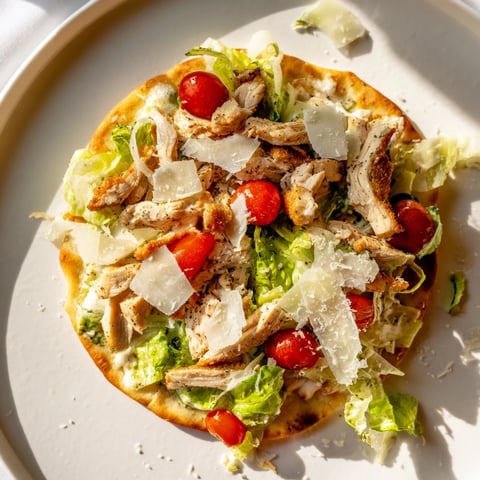Golden, crispy Chicken Caesar Flatbread topped with grilled chicken, romaine, and creamy Caesar dressing.