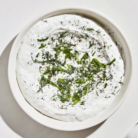 A close-up of creamy, herb-flecked Greek Yogurt Herb Dip, perfect with crisp veggie sticks.