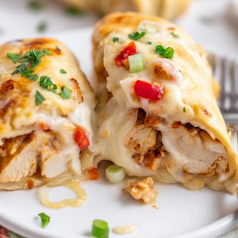 Warm, cheesy Cajun Chicken Alfredo Pizza Rolls oozing sauce, garnished with fresh parsley.