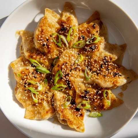 Golden brown air fryer frozen dumplings, glistening with sesame oil, ready to be served hot.