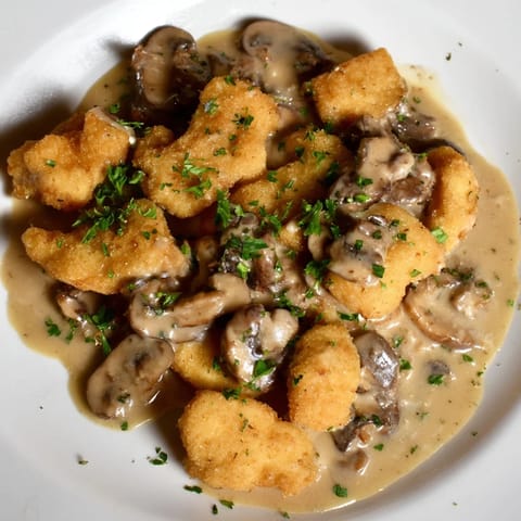 Tender Creamy Chicken Stroganoff over egg noodles, looking rich and inviting with fresh parsley as garnish.