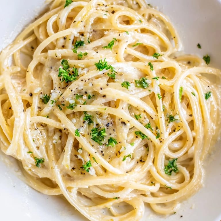 Garnish your Creamy Three-Cheese Spaghetti with parsley for a fresh, vibrant, flavorful pasta meal.