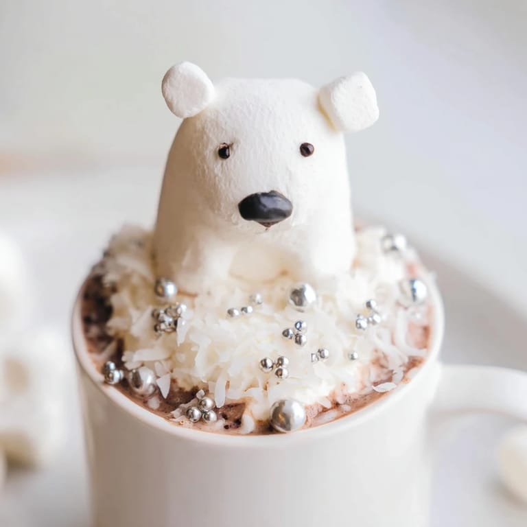 A festive platter of Polar Bear Hot Chocolate, garnished with whipped cream and snowy coconut flakes.