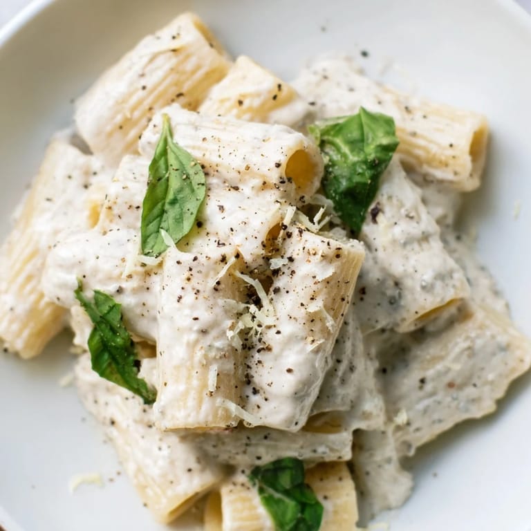 A bowl of delicious creamy cottage cheese pasta showcases the perfectly coated pasta and inviting texture.
